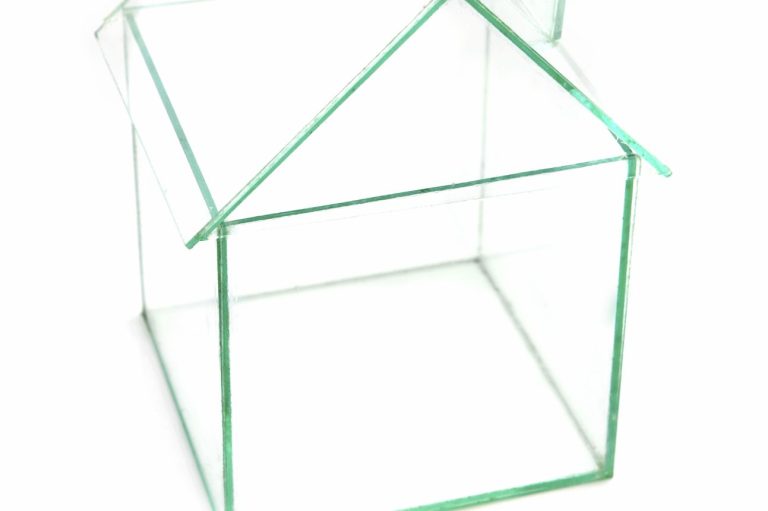 Clear glass house model with a simple roof structure.