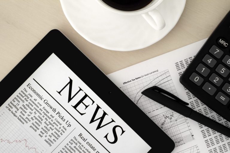 Newspaper titled "NEWS" alongside a coffee cup, calculator, and pen on a desk.