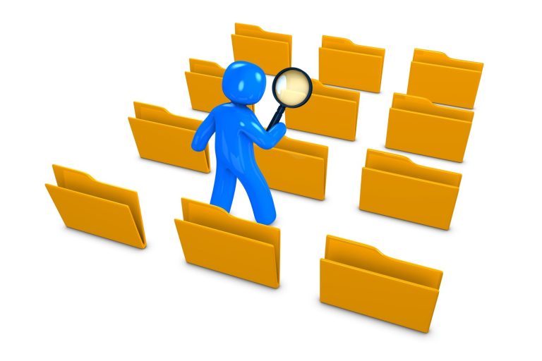 Blue figure holding a magnifying glass among yellow file folders.