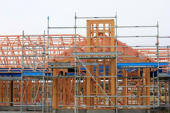 Construction site with wooden framing and scaffolding for a building under construction.